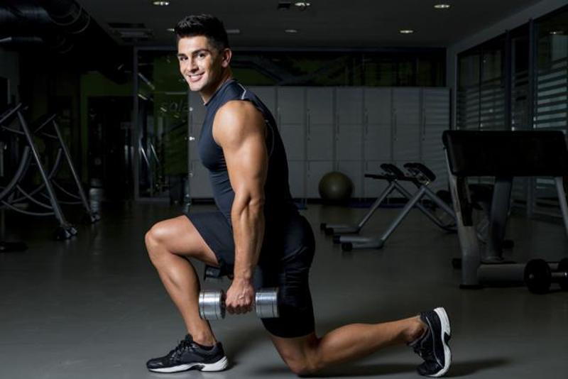 gym-man-doing-dumbbell-lunges-in-a_9e3ef5f6-3609-11e6-b762-306eb096a216